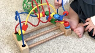 乳児がカラフルな知育玩具で遊んでいる様子。脳の発達を促す遊びの一場面。