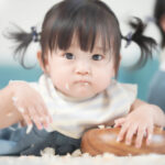赤ちゃんが手づかみ食べをしている様子。発達を伸ばす4つの効果がある。