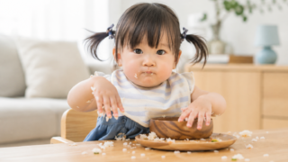 1歳の子どもが手づかみでご飯を食べている様子