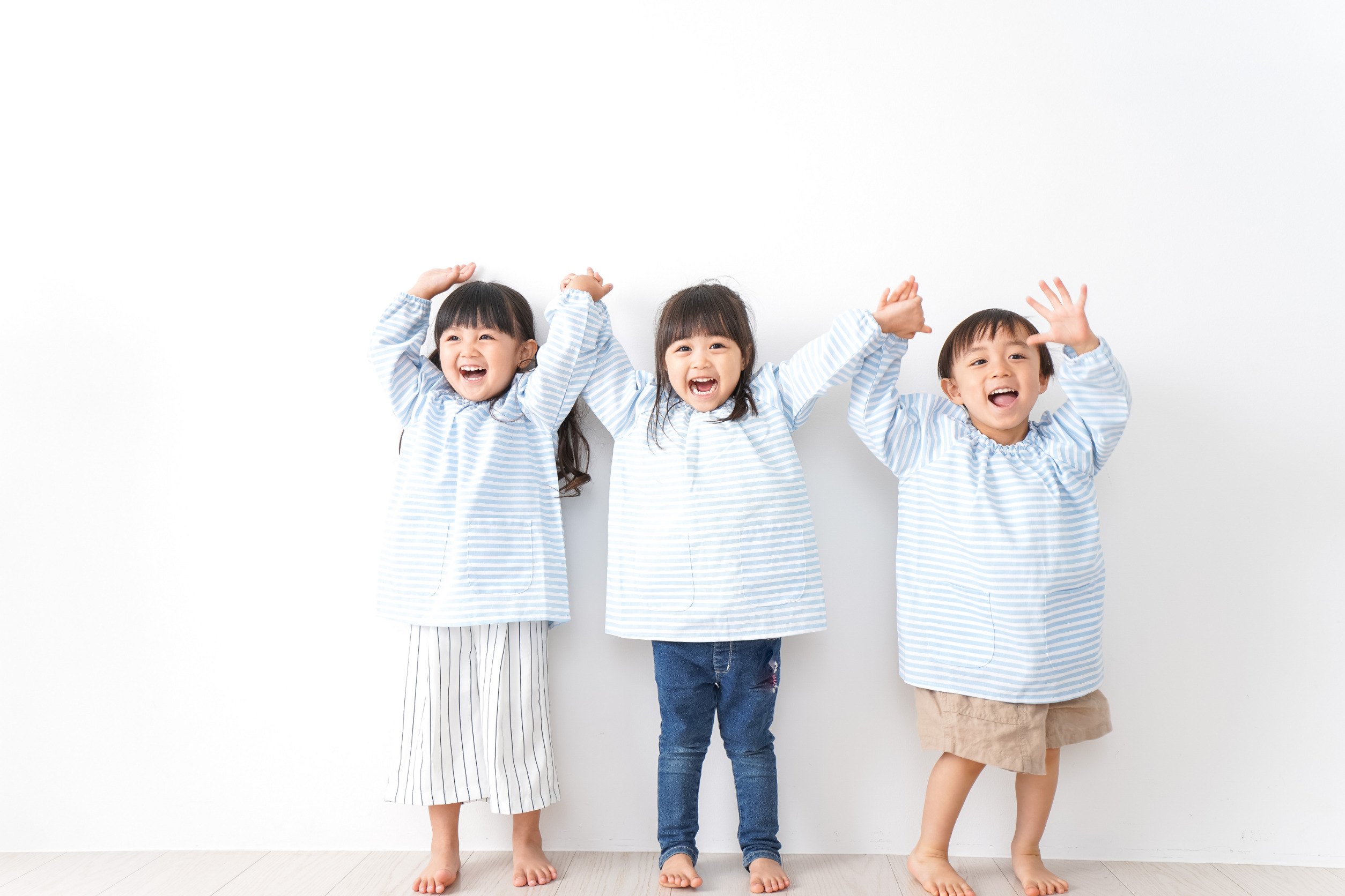 両手をあげている3人の幼児
