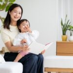 絵本を読みながら笑顔で過ごす母親と幼い子ども