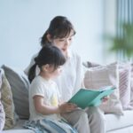 有名大学に進む子が３歳までにしている習慣　絵本を読む母と幼い娘の様子