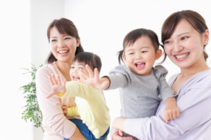 子どもを抱っこして笑顔で過ごす2組の親子