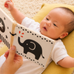 赤ちゃんが大人に見せてもらっている絵本をじっと見つめている様子